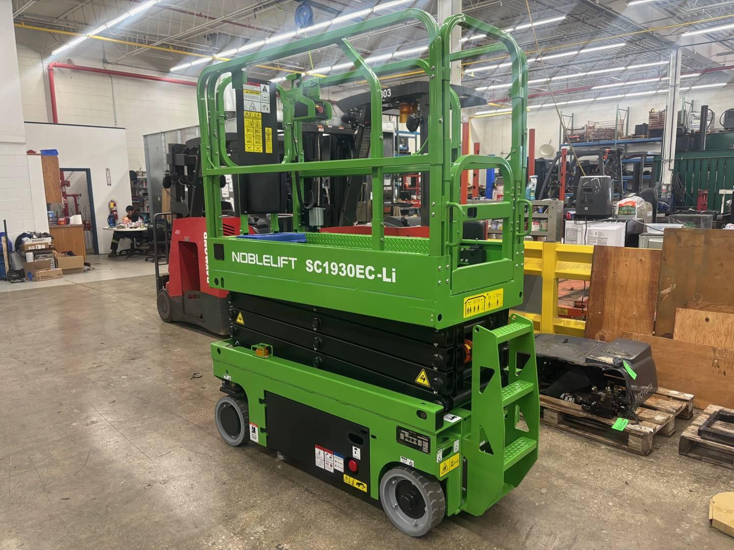Green Noblelift scissor lift platform in warehouse